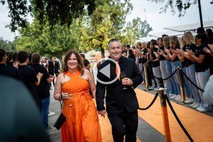 a couple walks the orange carpet at the Orange and Black ball